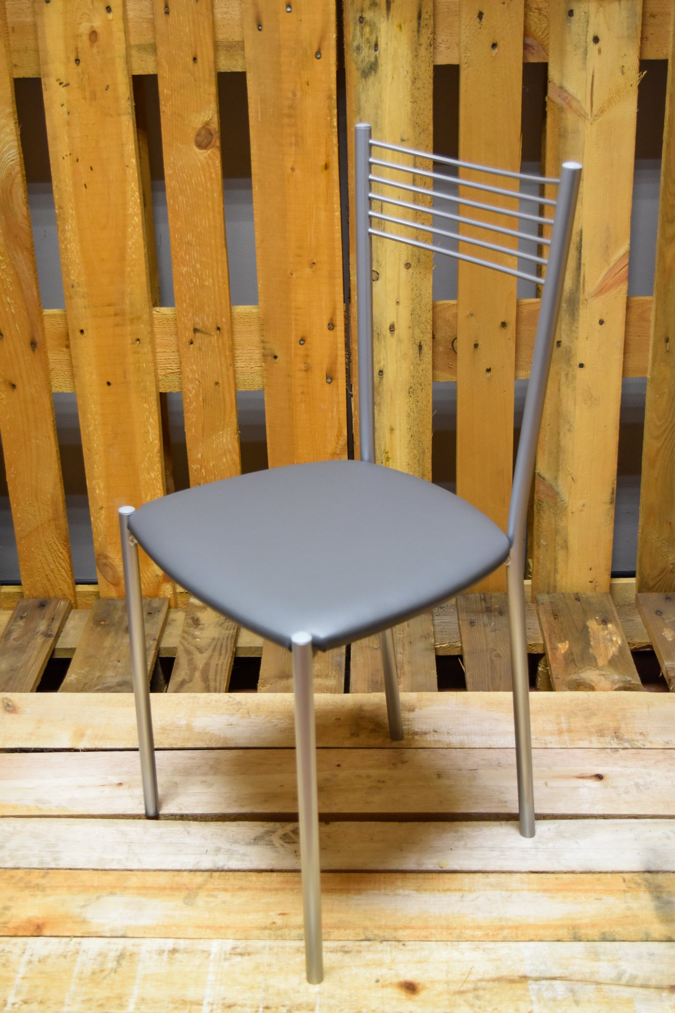 Stock chairs model MA10 in aluminum color with dark gray padded seat